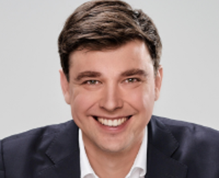 Man in a suit smiling to the camera